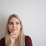 Portrait of a pensive woman with a thoughtful expression against a white background.